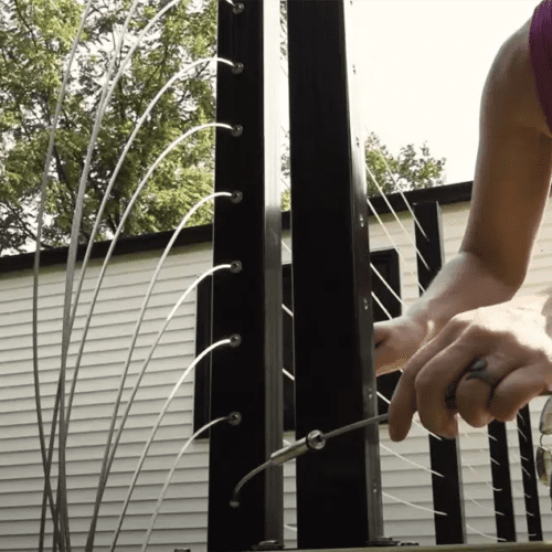 Theresa threads the cables from bottom to top, waiting to tighten them with an Allen wrench until after all the cables are in place, which a homeowner can use for future tensioning needs.