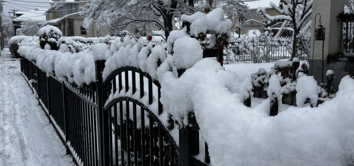Snow on a fence in front of a house